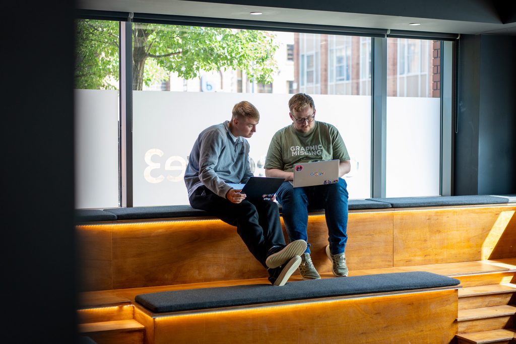 Two men looking at a screen together in an office space